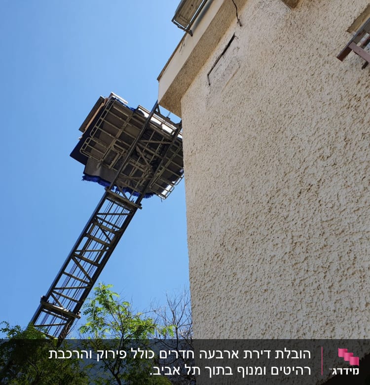 מנוף משא מעביר חפצים לקומה גבוהה בבניין